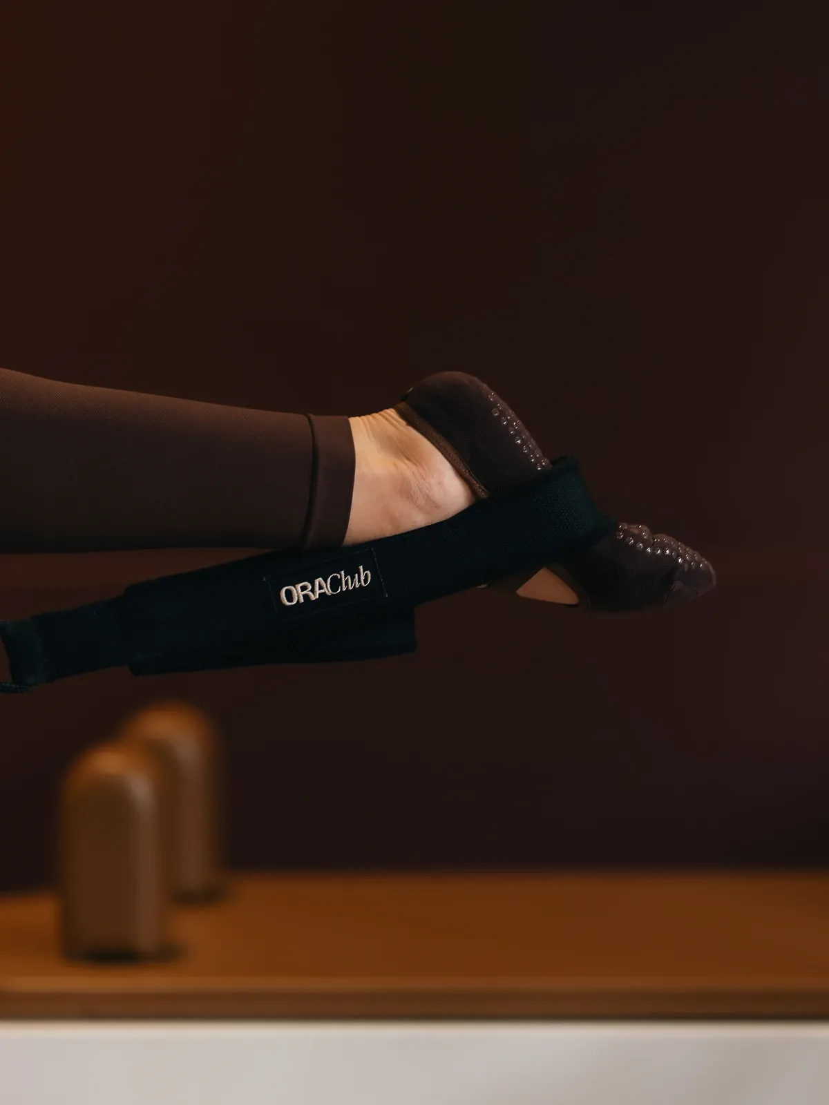 Pied en chausson antidérapant glissé dans une sangle Ora Club du Reformer